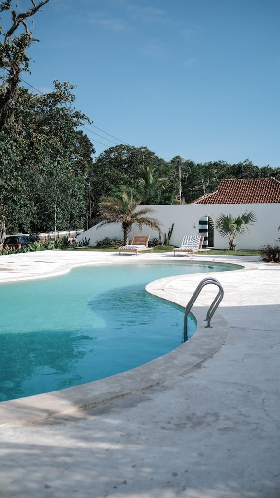 A serene luxury villa with a private pool surrounded by tropical greenery, perfect for summer relaxation.